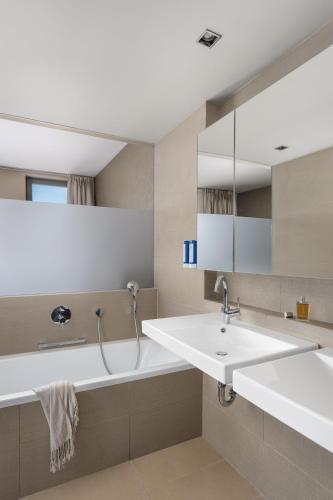 a bathroom with a sink and a bath tub at Zijin Hotel Belgrade in Belgrade