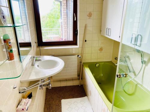 y baño con lavabo y bañera verde. en WORKATION Treehouse Nature Park Gold Centre, Balcony, Kitchen, en Wiesbaden