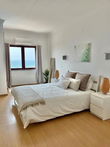 埃里塞拉的住宿－Ribeira DIlhas Beach Apartment，白色的卧室设有一张大床和一个窗户