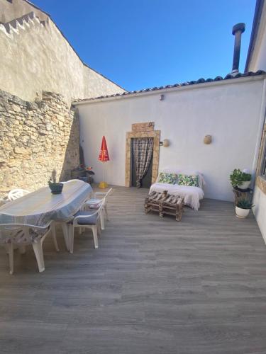 a patio with a table and chairs and a bed at Casa Carrasquillas in Cañada del Hoyo