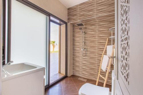 uma casa de banho com um chuveiro, um WC e um lavatório. em Villa Vista , Piscine 22m , Jeux jardins , Terrain squash em Marraquexe