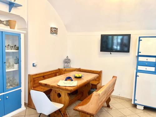 a dining room with a wooden table and chairs at Villetta partenopea a pochi passi dal mare in Meta