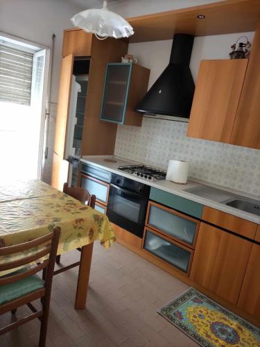 uma cozinha com uma mesa e um fogão forno superior em Casa Maria em Terracina