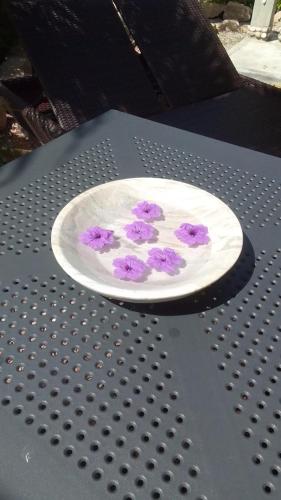 a plate with flowers on it sitting on a table at Oceane L'union Villa in La Digue