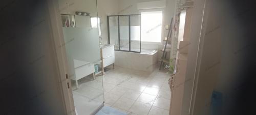 a bathroom with a tub and a sink and a mirror at Maison au calme a Arnage in Arnage