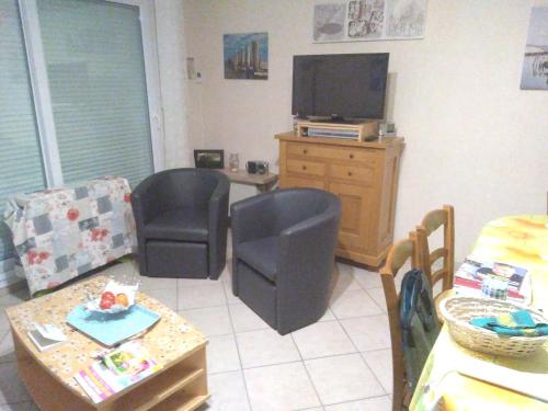 un salon avec deux chaises et une télévision dans l'établissement Appartement cosy avec vue sur la mer à Camiers - 46 m², à Camiers