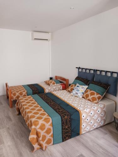 two beds sitting next to each other in a room at T2 60 m² - Au cœur de tout in Gignac