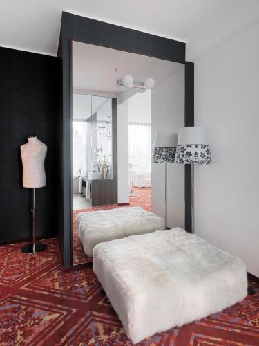 a bedroom with two beds and a mirror at Kameha Grand Bonn in Bonn