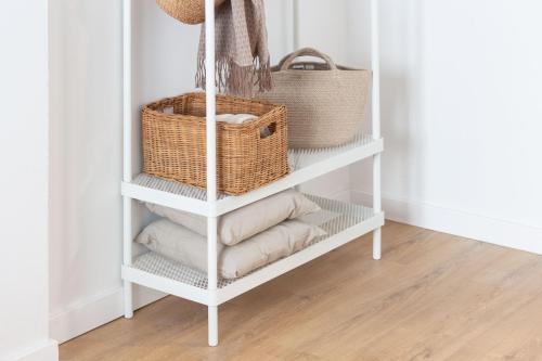 a white book shelf with baskets and towels at VLC Host - Lleons Cityscape in Valencia