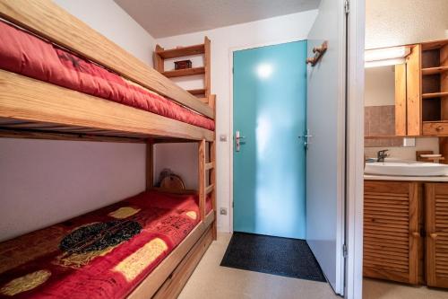 een slaapkamer met 2 stapelbedden en een wastafel bij Nikye Morillon 5 personnes in Morillon