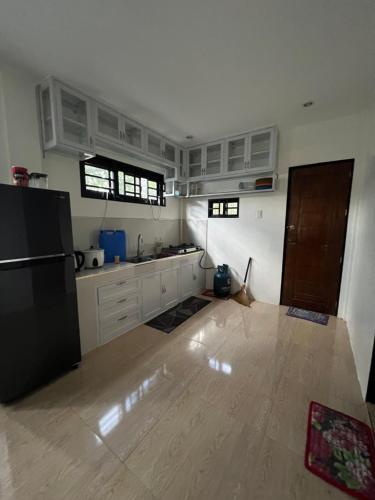 a kitchen with white cabinets and a black refrigerator at Cordon, Isabela Staycation House in Cordon