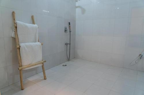 a bathroom with a shower with a towel on a chair at Swiss House in Jodhpur