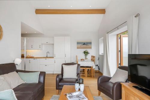 a living room with a couch and a tv at Rosemerryn in Marazion