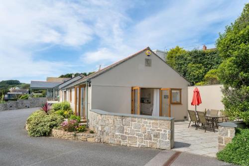 a small white house with a stone wall at Rosemerryn in Marazion