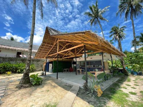 a pavilion with a roof on top of a house at Dawn Patrol Siargao in General Luna