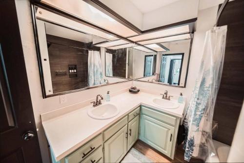 a bathroom with two sinks and a large mirror at Casa on the Cove in Chandler