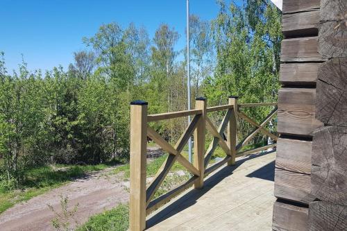 a wooden bridge over a dirt road with trees at UTSIKTEN -exklusivt nybyggt timmerhus -Plintsberg. in Tällberg