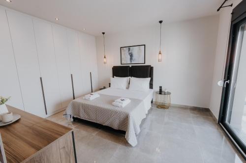 a bedroom with a bed and a large window at Pearl Apartel in Volos