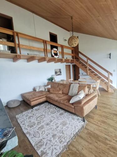 a living room with a couch and a staircase at NEB-THUN Seehaus Einigen in Einigen