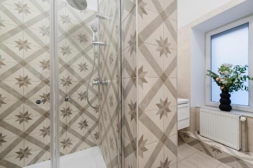 y baño con ducha y puerta de cristal. en Cracovian House by LoftAffair, en Cracovia
