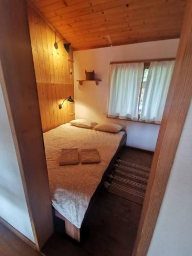a small room with a bed and a window at NEB-THUN Seehaus Einigen in Einigen