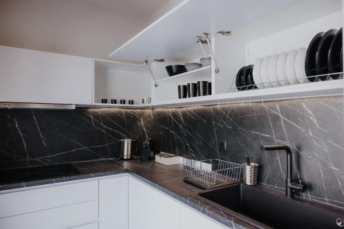 a kitchen with black and white marble counters and a sink at Pearl Apartel in Volos