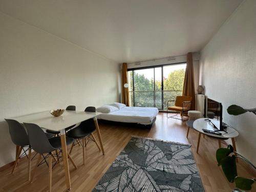 un salon avec une table, des chaises et un canapé dans l'établissement Reims Place d'Erlon Hyper centre, à Reims