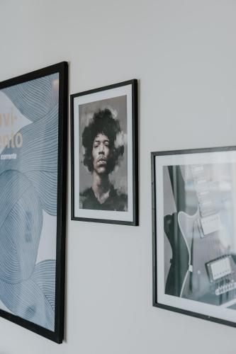 two framed photographs of a man are hanging on a wall at Pearl Apartel in Volos