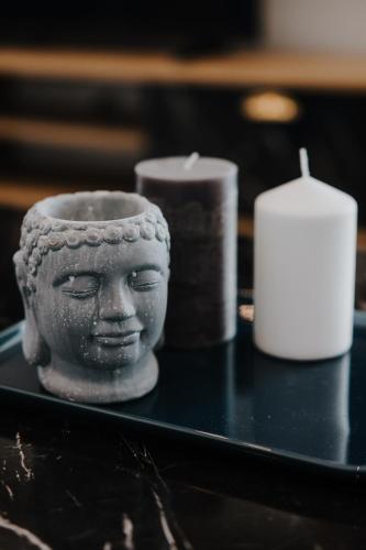 a statue of a head on a table with candles at Pearl Apartel in Volos