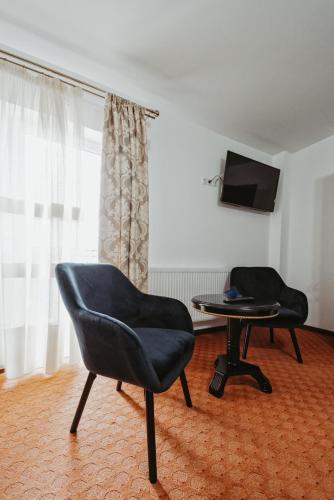 a room with two chairs and a table and a television at Complex Turistic Constantin Bucovina in Câmpulung Moldovenesc
