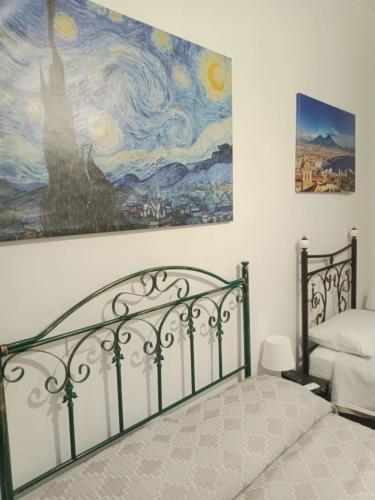 a bedroom with a bed and a painting on the wall at I Rifugi di Noah Santa Maria a Vico- in Santa Maria a Vico