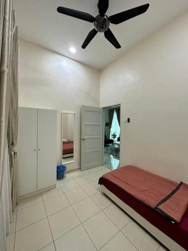 a bedroom with a bed and a ceiling fan at RumahKu Homestay, Taman Jasin Perdana in Jasin