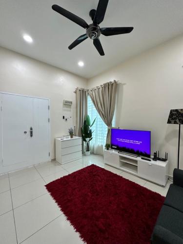 a living room with a ceiling fan and a tv at RumahKu Homestay, Taman Jasin Perdana in Jasin