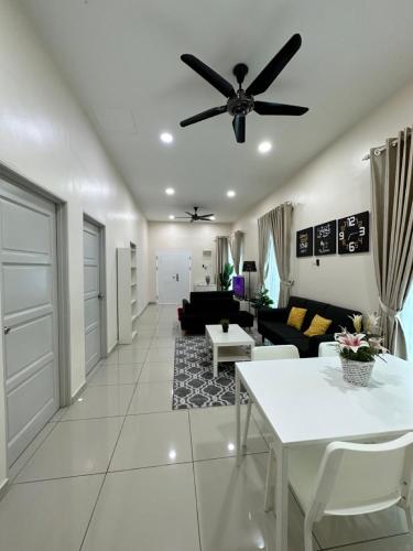 a living room with a ceiling fan and a table at RumahKu Homestay, Taman Jasin Perdana in Jasin