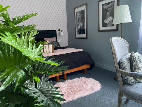 a bedroom with a bed and a chair and a plant at Parker et Tammy in Saint-Gelais