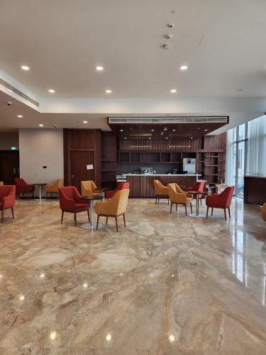 a lobby with chairs and tables in a building at Kyriad Hotel Salalah in Salalah