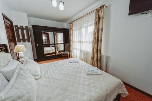 a bedroom with a white bed and a window at Complex Turistic Constantin Bucovina in Câmpulung Moldovenesc