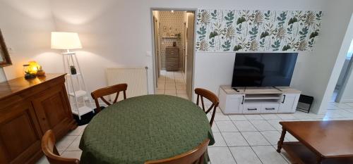 a living room with a table and a television at T2 55m² tout confort avec jardin. Cuisine et équipements neufs. Wifi TV parking in Balma