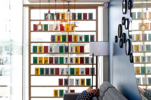 a living room with a wall of books at Hampton by Hilton Tours Centre, France in Tours