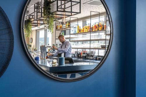 a man standing at a bar in a mirror at Hampton by Hilton Tours Centre, France in Tours