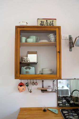 a wooden shelf on a wall with dishes on it at Casa Tesor - your design home in Mantua city center in Mantova