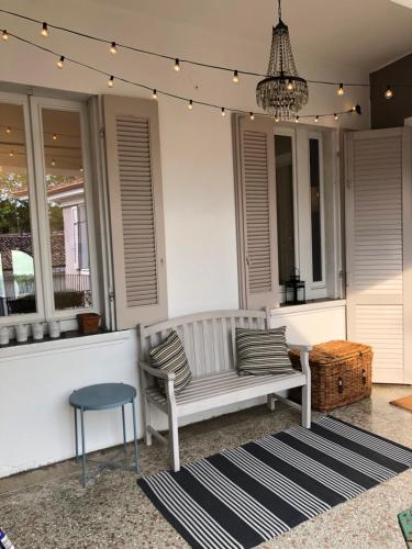 a porch with a bench and a stool and a chandelier at Casa Tesor - your design home in Mantua city center in Mantova