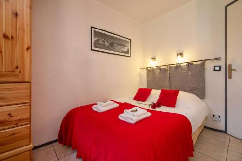 a bedroom with a bed with red and white towels on it at Chamonix Sud - Jonquilles 30 - Happy Rentals in Chamonix-Mont-Blanc