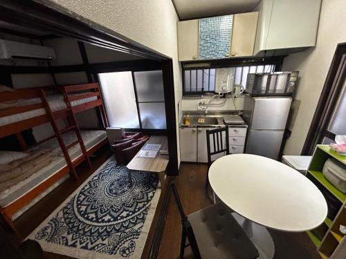 a small kitchen with a table and a white table at 1970's Japanese style dorm house in Tokyo