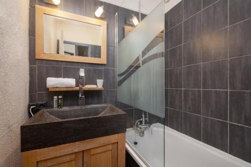 a bathroom with a sink and a tub and a mirror at Chamonix Sud - Jonquilles 30 - Happy Rentals in Chamonix-Mont-Blanc