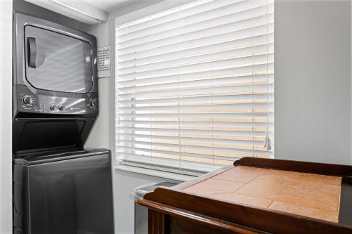 a kitchen with a refrigerator and a microwave at 208 Madeira Norte Condo in St Pete Beach