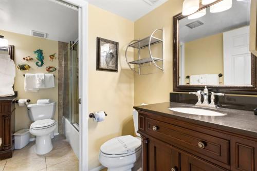 a bathroom with a sink and a toilet and a mirror at 208 Madeira Norte Condo in St Pete Beach
