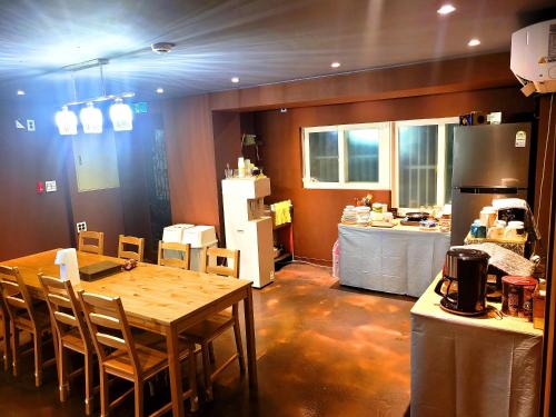 a kitchen with a table and a kitchen with a refrigerator at Good Guesthouse in Seoul