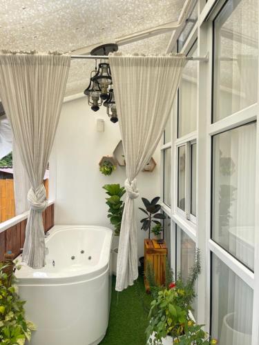 a bath tub in a bathroom with curtains at Phu Morinn Cafe&Camping in Mon Jam