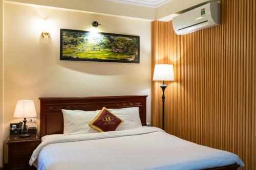 a hotel room with a bed and a picture on the wall at May Ho Hotel Sapa in Sa Pa